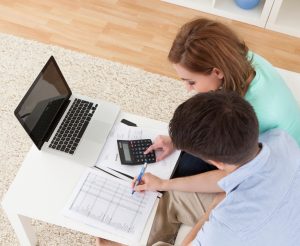 Portrait of young happy couple calculating budget